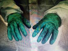 Un operario de una central eléctrica muestra sus guantes de trabajo.